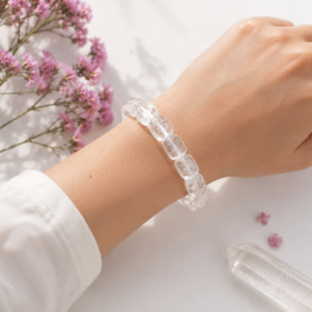 Clear Quartz Crystal Bracelet worn on wrist with soft pink flowers