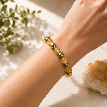 Citrine and Pyrite bracelet worn on the wrist in warm natural light with greenery and crystals