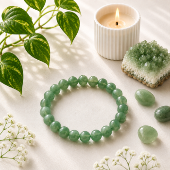 Green Aventurine Crystal Bracelet with polished green beads styled with greenery, crystals and a candle on a soft cream background.