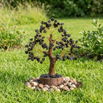 Handcrafted Black Tourmaline Crystal Tree with natural black tourmaline crystal chips in a peaceful outdoor garden setting