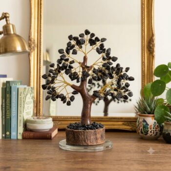 Handcrafted Black Tourmaline Crystal Tree with natural black tourmaline crystal chips in a front of mirror with plants and books in the background
