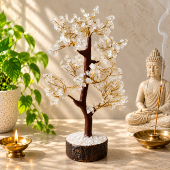 Clear Quartz Crystal Tree with golden wire branches displayed with a Buddha statue, diya, and green plant