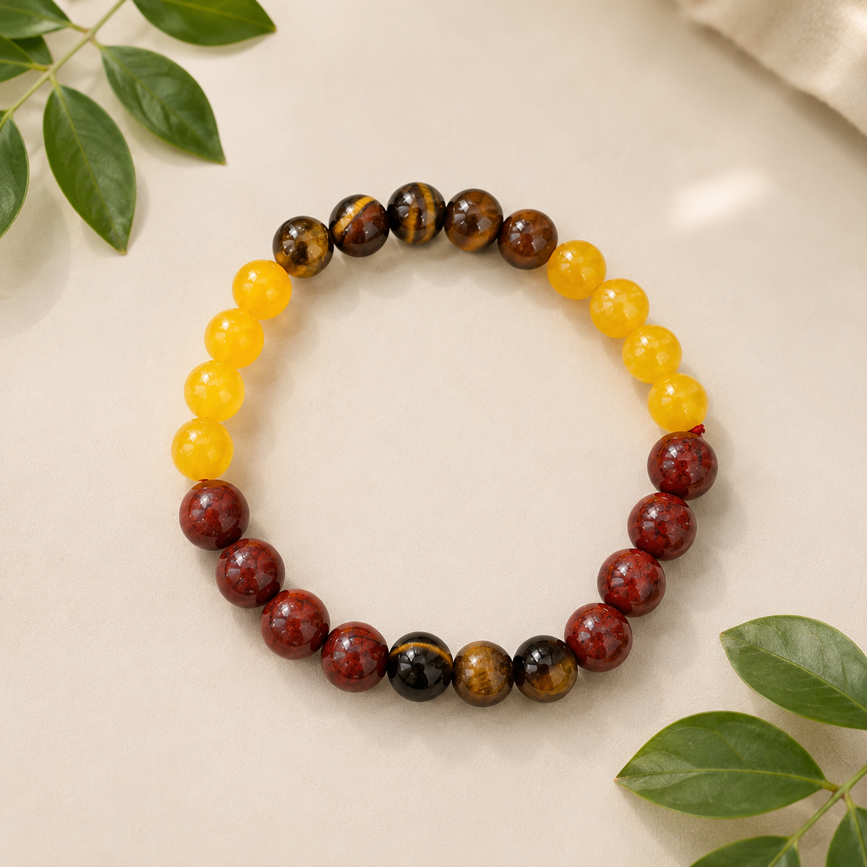 Sinh Rashi Bracelet made with Citrine, Tiger Eye and Sunstone 8 mm natural gemstone beads on a premium beige background with green leaves.