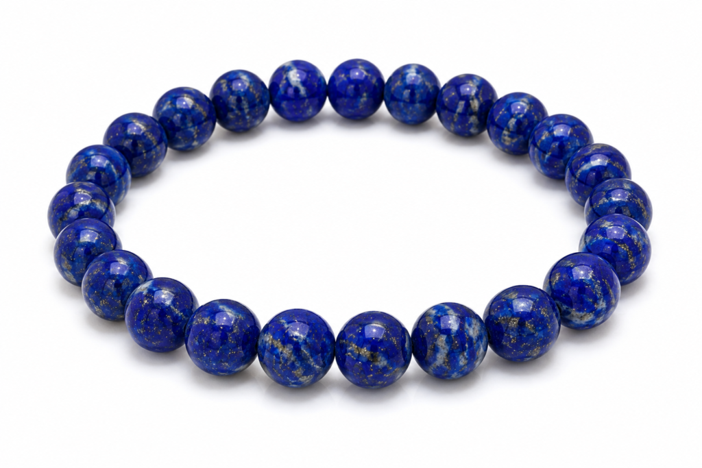 Natural Lapis Lazuli gemstone bracelet with deep royal blue beads and subtle golden pyrite flecks on a white background, traditionally associated with the Third Eye Chakra, wisdom, intuition, and self-awareness.