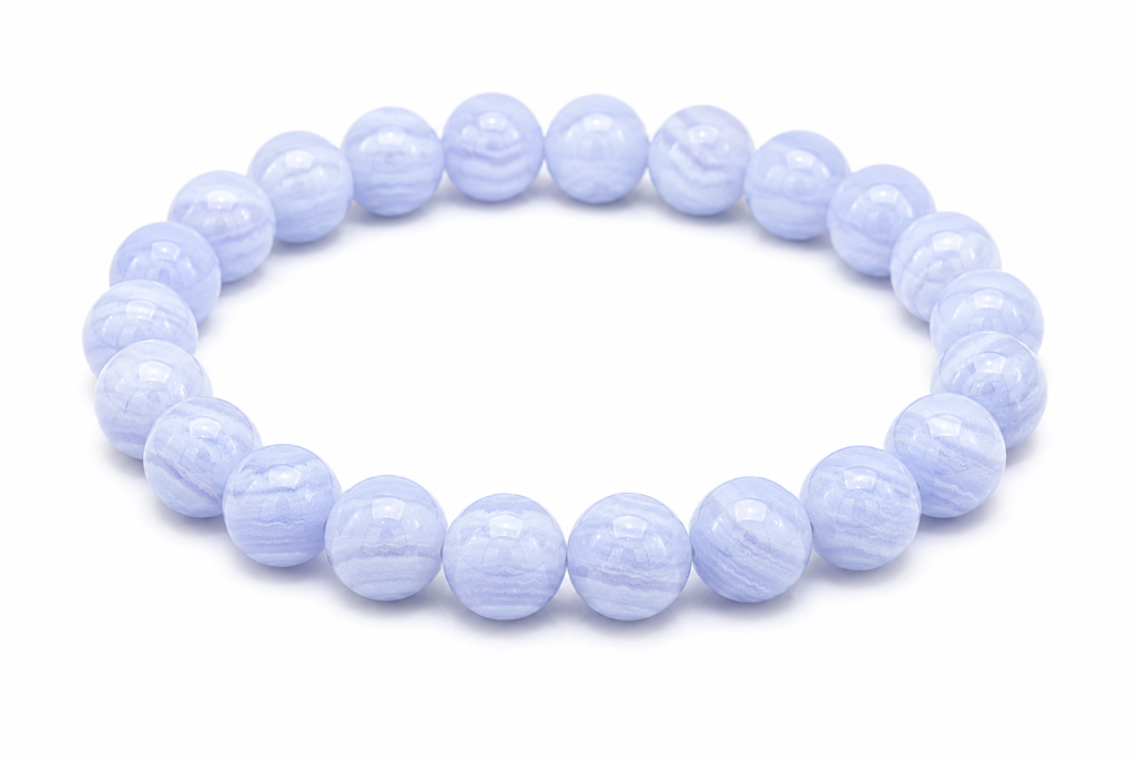 Blue Lace Agate bracelet featuring polished light blue banded gemstone beads on a white background. Traditionally associated with calm communication, self-expression, and the Throat Chakra.