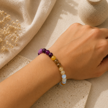 Dhanu Rashi Sagittarius Bracelet with purple, yellow and opalescent beads worn on a wrist.